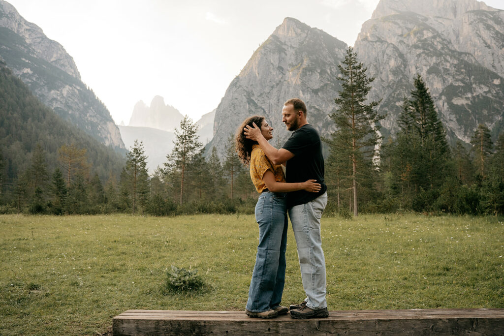 Couple embraces near mountains and forest