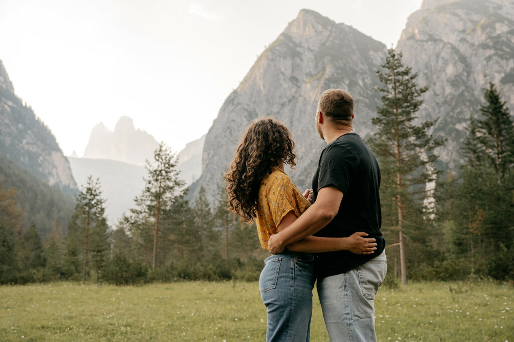 Couple embracing, admiring scenic mountain view.