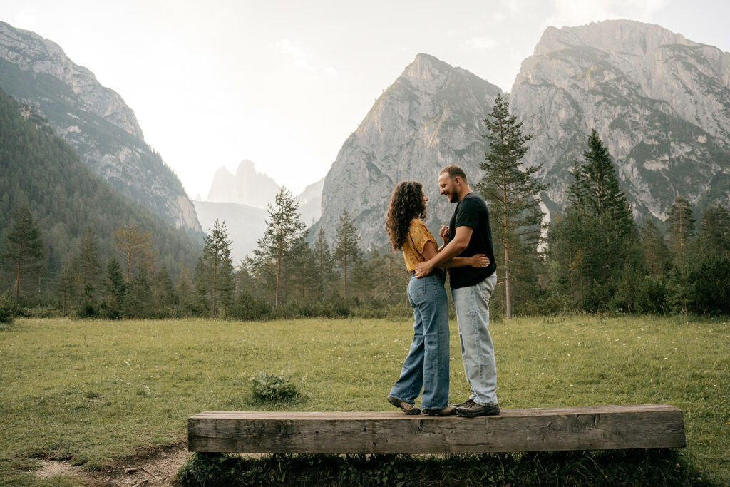 Couple embracing on bench with mountain background