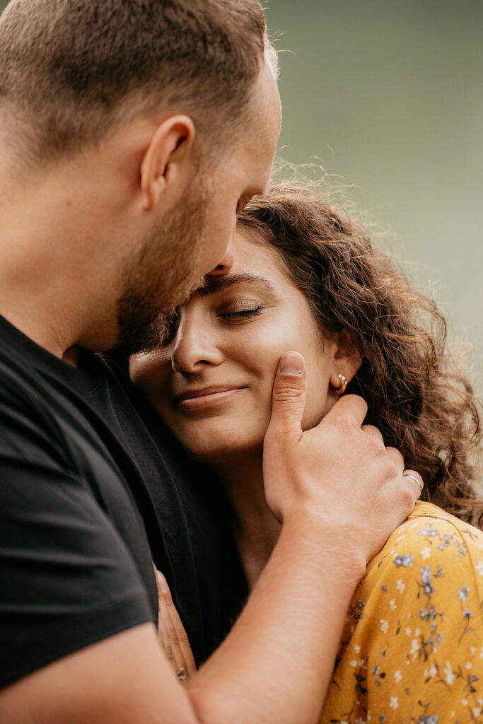 Couple embracing with eyes closed, smiling peacefully.