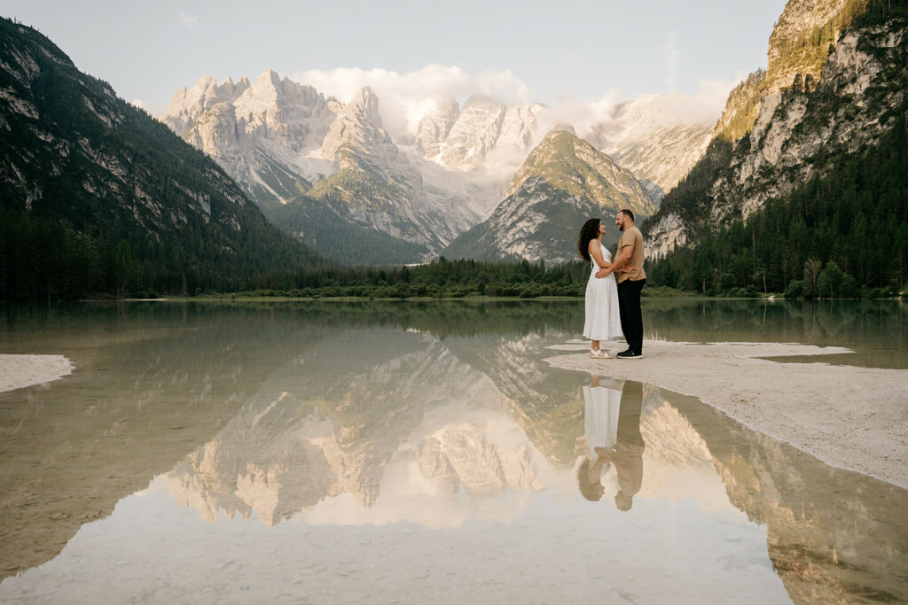 Couple embraces by picturesque mountain lake.