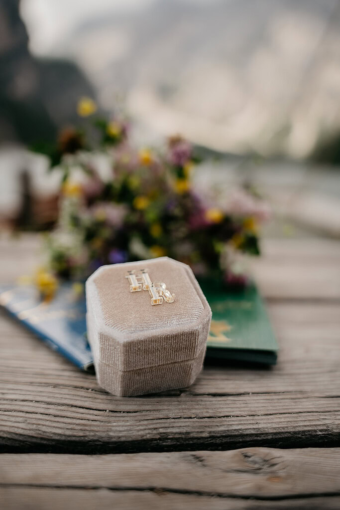 Jewelry box with gold earrings on wooden table.