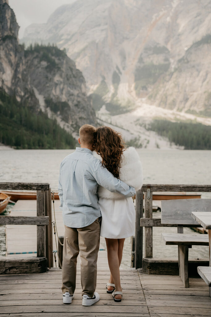 Couple embracing by mountain lake view.