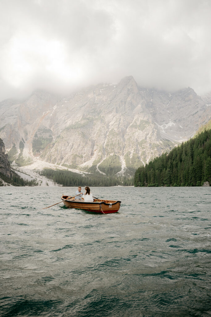 Couple rowing boat on mountain lake