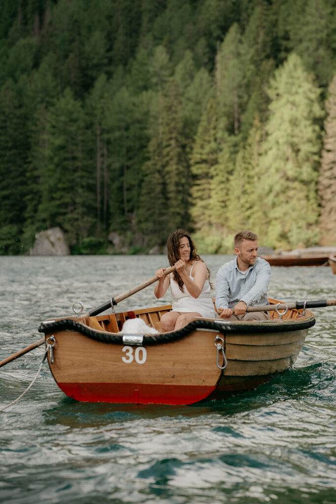 Couple rowing boat on forested lake