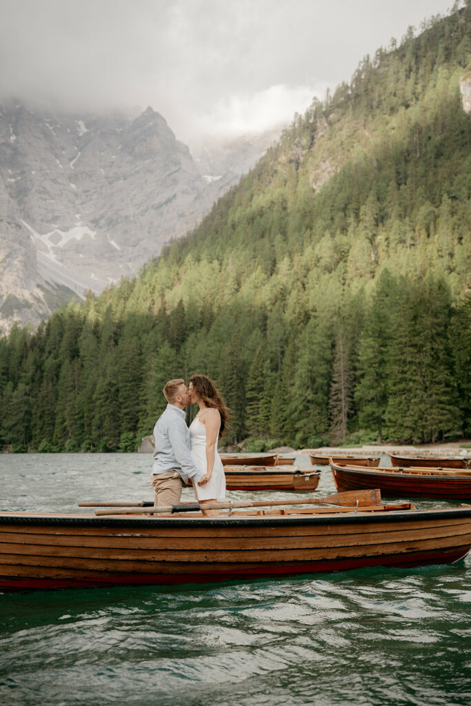 Couple kissing on boat, scenic mountain background