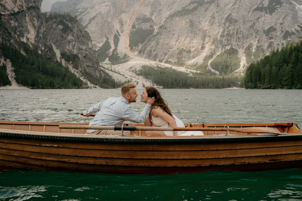 Couple kissing on a boat in scenic lake.