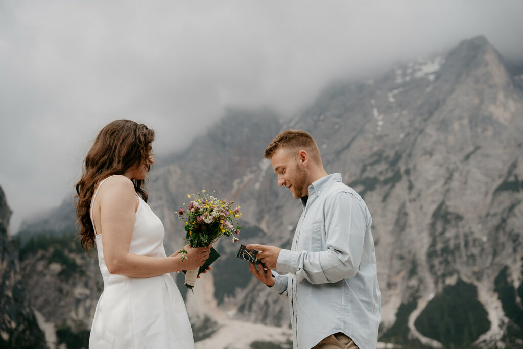Couple exchanging vows in mountainous setting.
