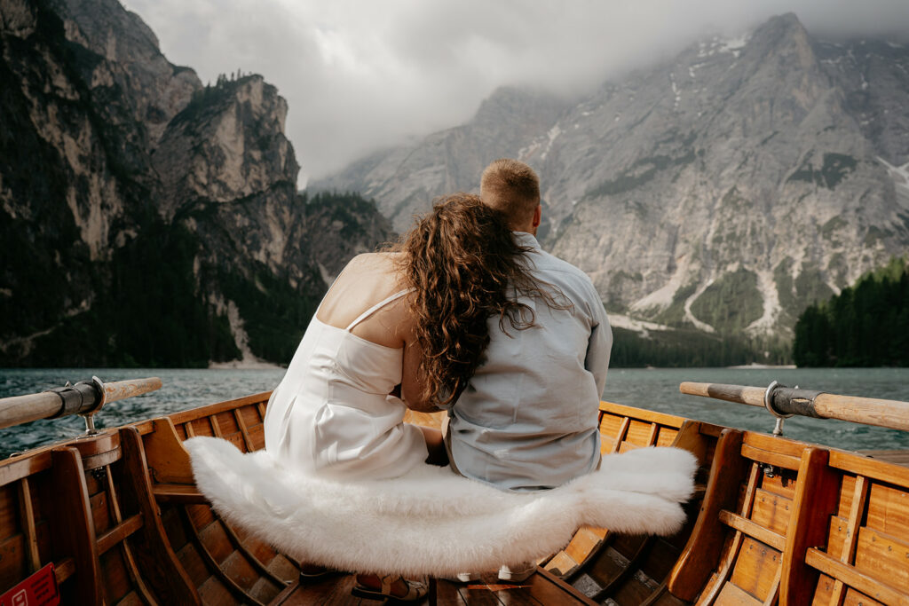 Couple on boat, cloudy mountain scenery background.