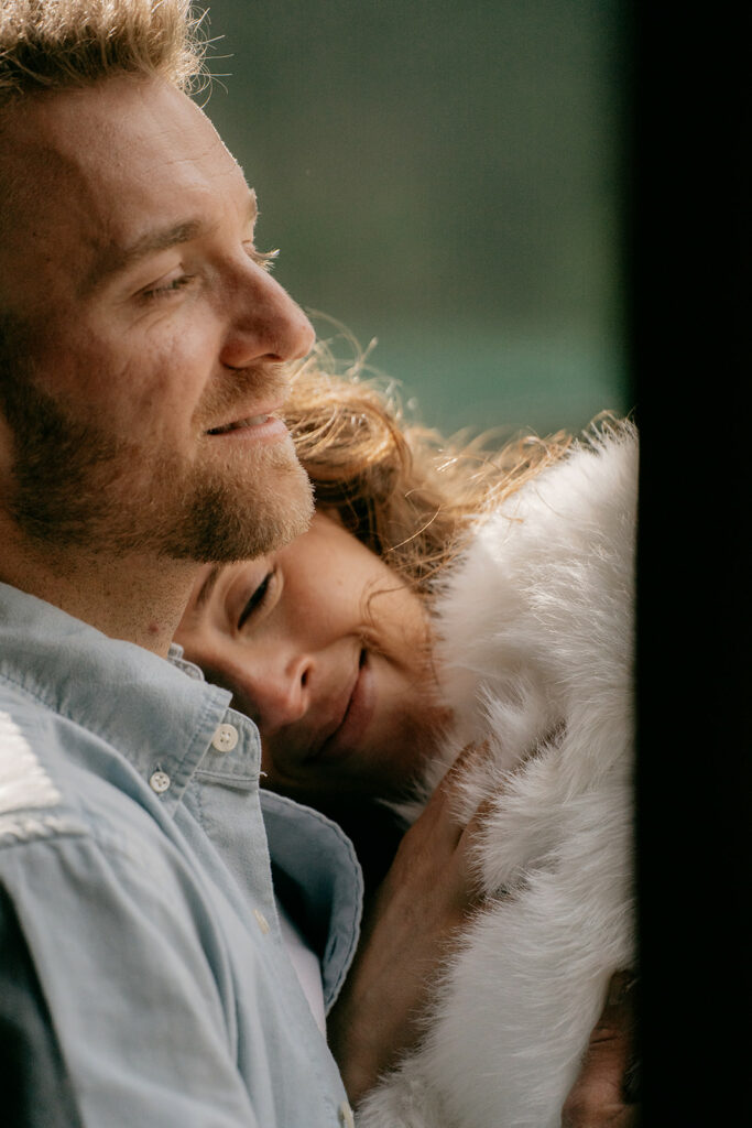 Couple hugging, woman resting on man's shoulder.