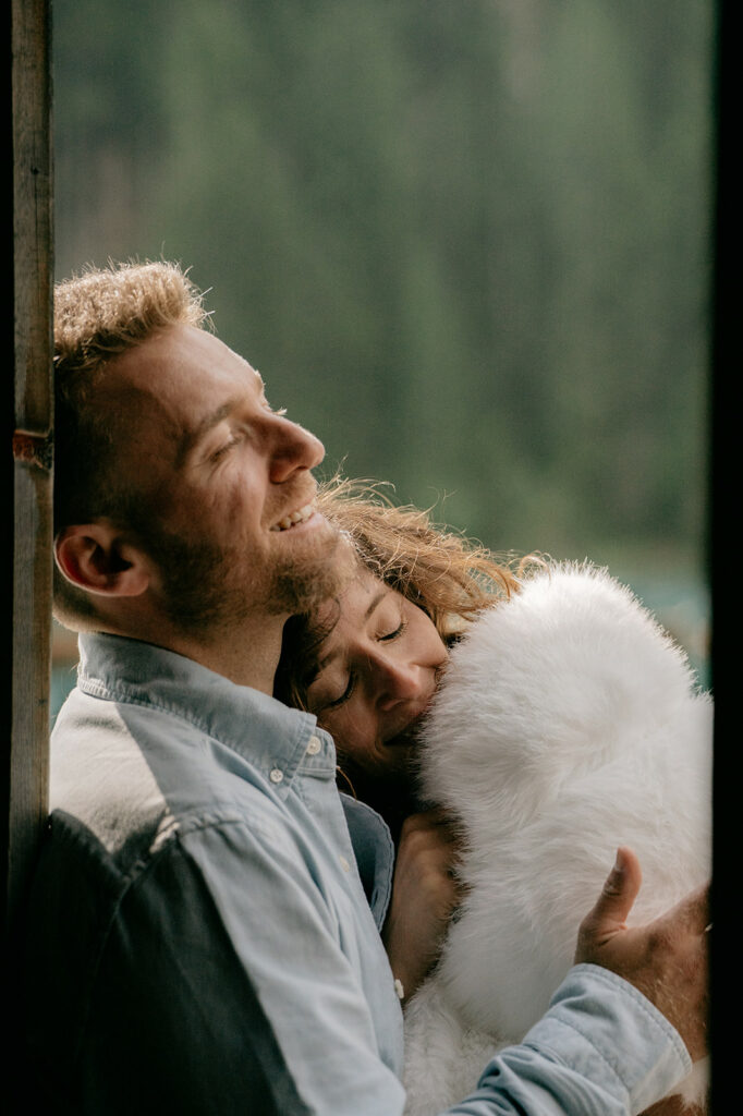 Couple hugging warmly by a window.