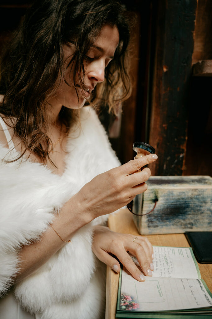 Woman stamping a notebook in cozy setting.
