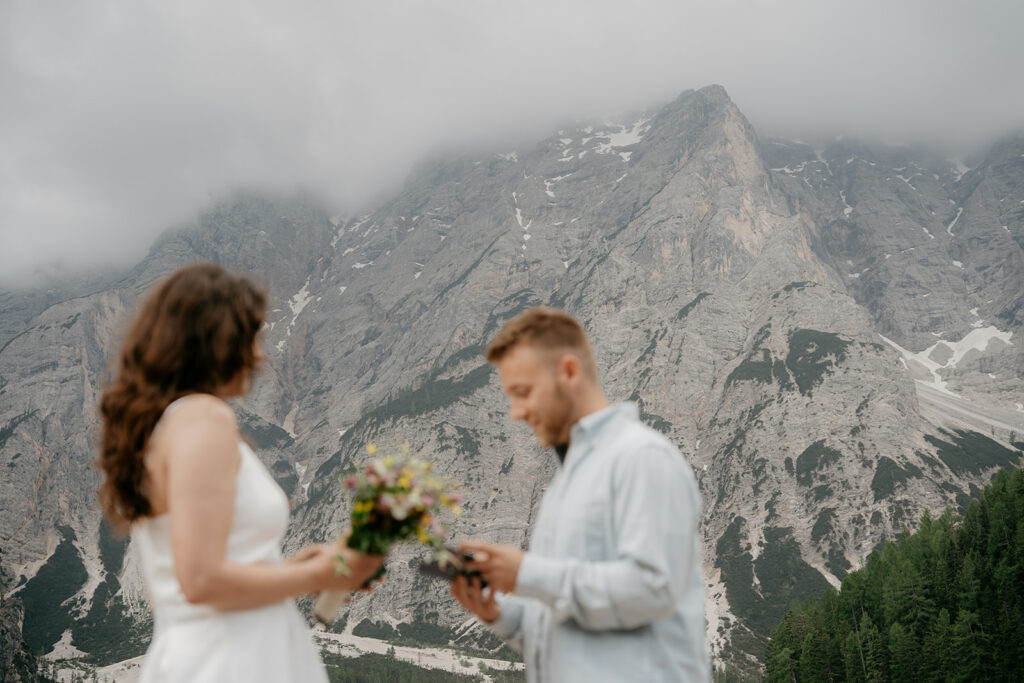 Couple holding flowers with mountain backdrop