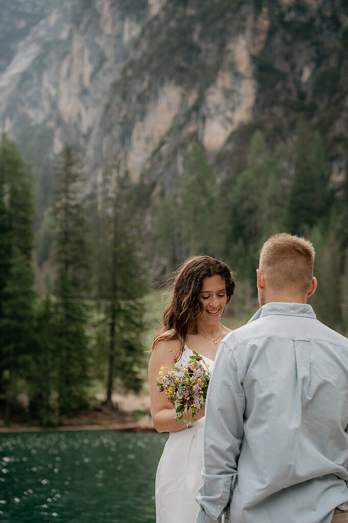 Couple exchanging vows by mountain lake.