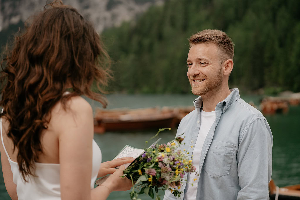 Couple exchanging vows by a lake.