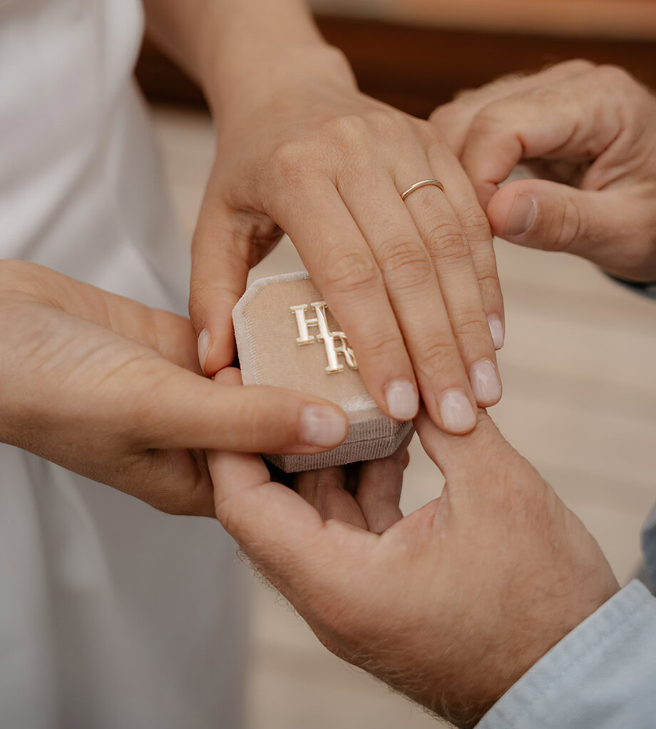 Man placing engagement ring on woman's hand