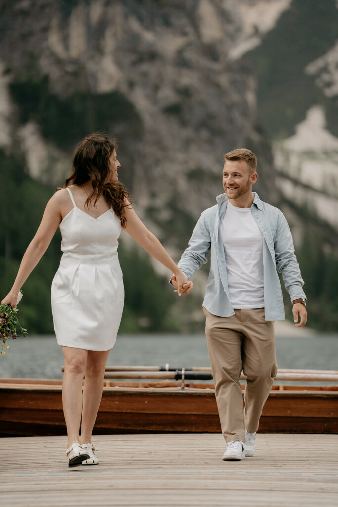 Couple walking hand in hand by the lake.