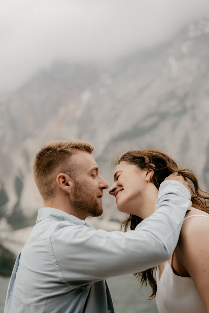 Couple smiling at each other, mountain background