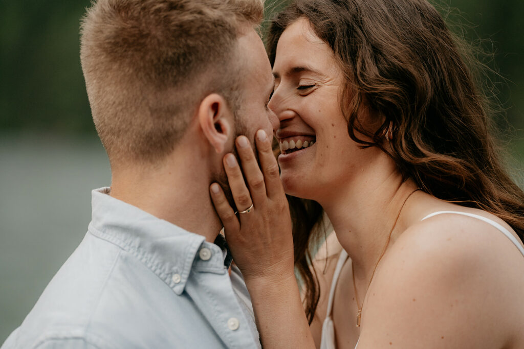 Couple smiling and embracing affectionately outdoors.