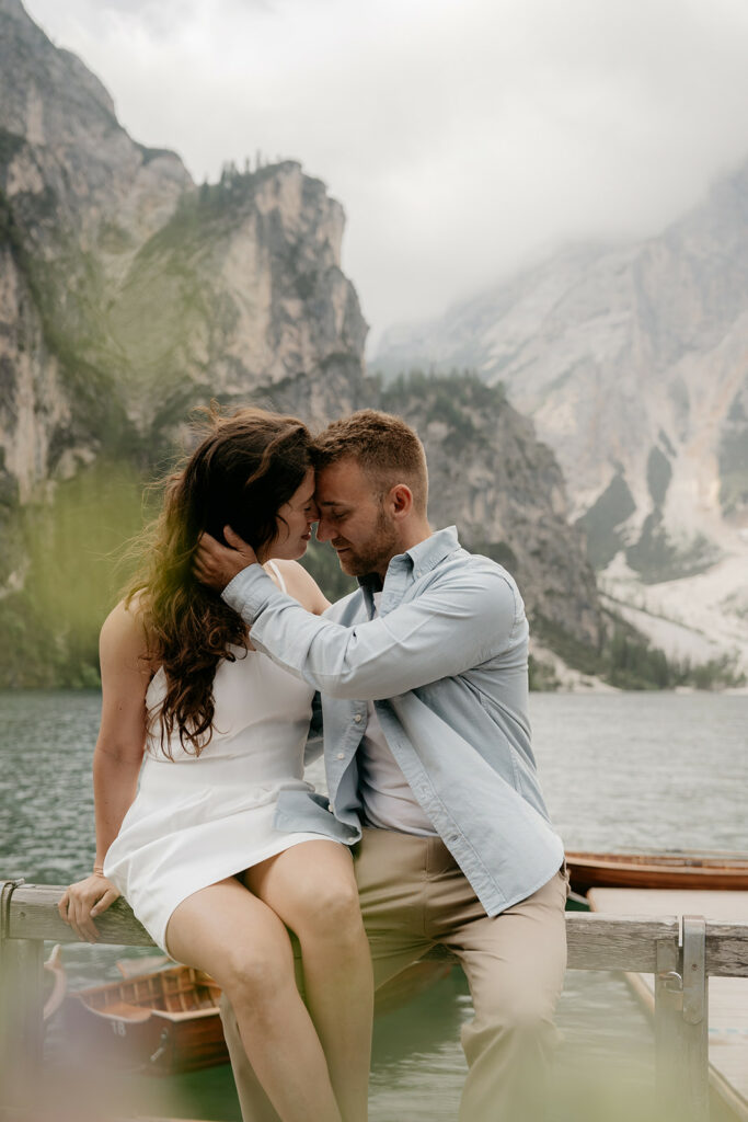Couple embracing by mountain lake.