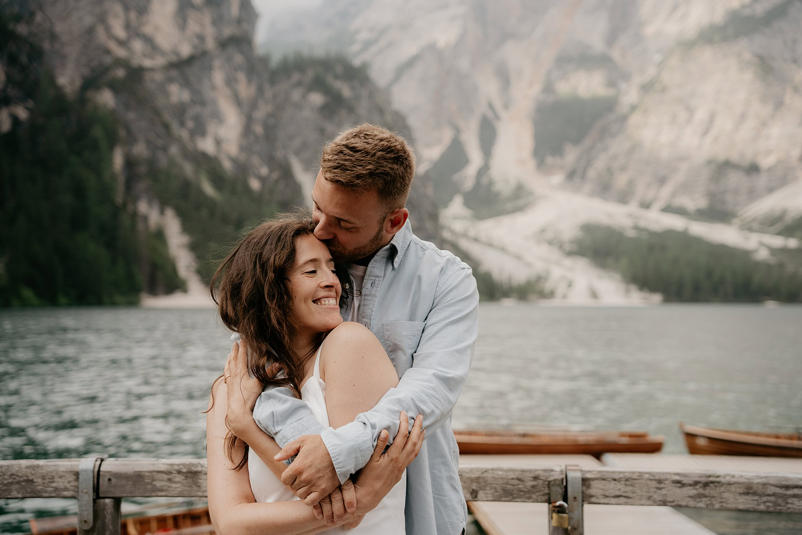 Couple embracing by a scenic mountain lake.