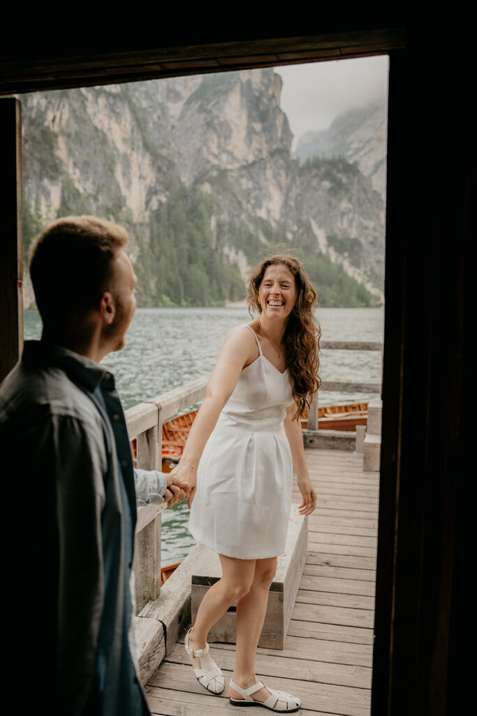 Couple smiling on a lakeside wooden deck
