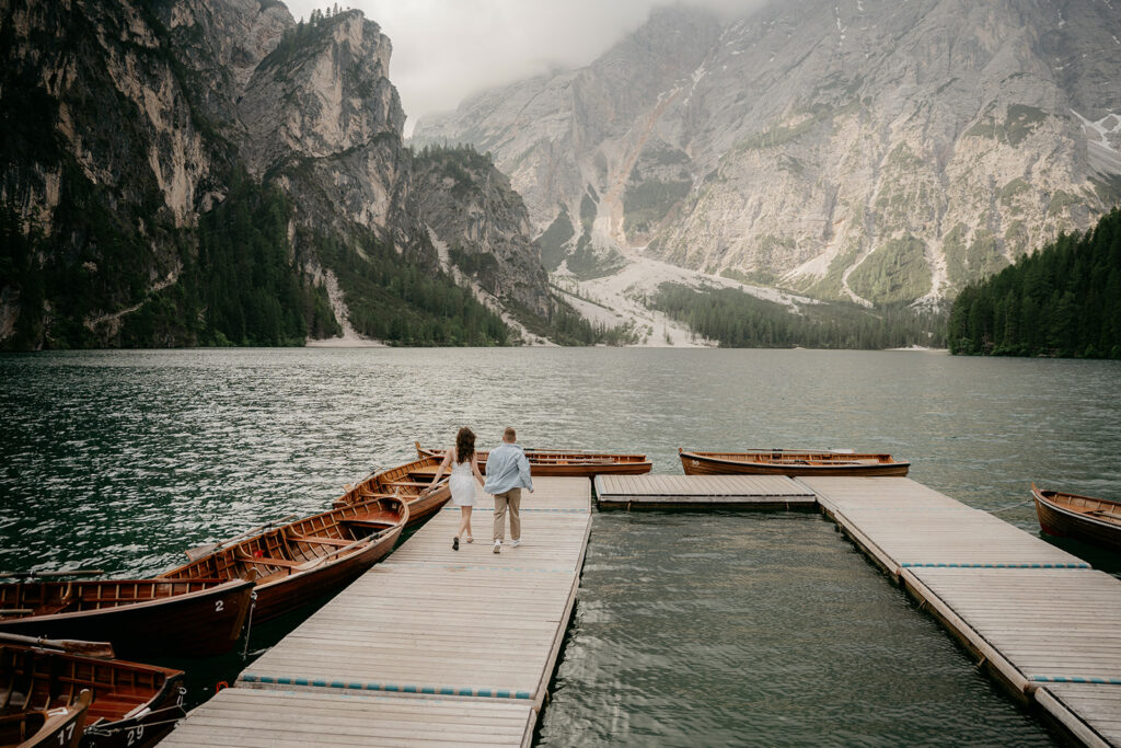 Couple walking on dock by mountain lake