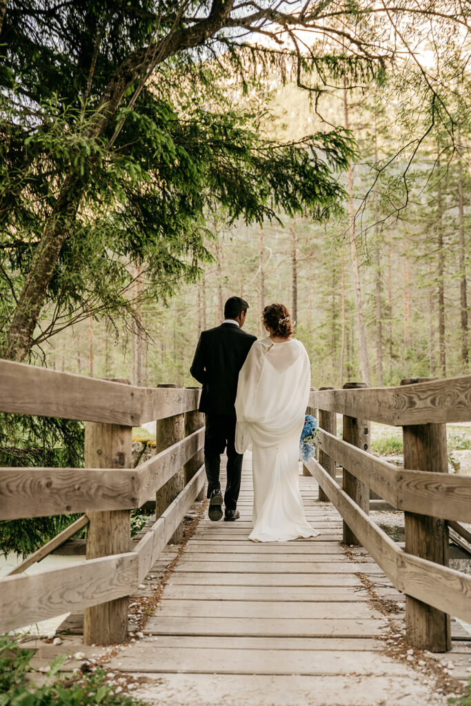 Couple walking on wooden bridge in forest