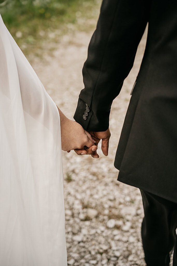 Bride and groom holding hands on wedding day.