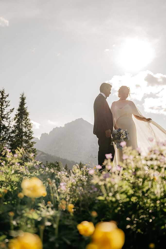 Bride and groom in scenic mountain meadow