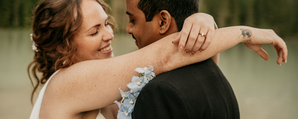 Wedding couple embracing joyfully outdoors