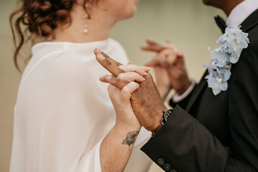 Couple holding hands during wedding ceremony.