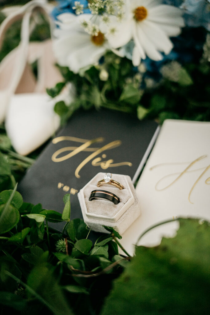 Wedding rings on vows book with flowers.