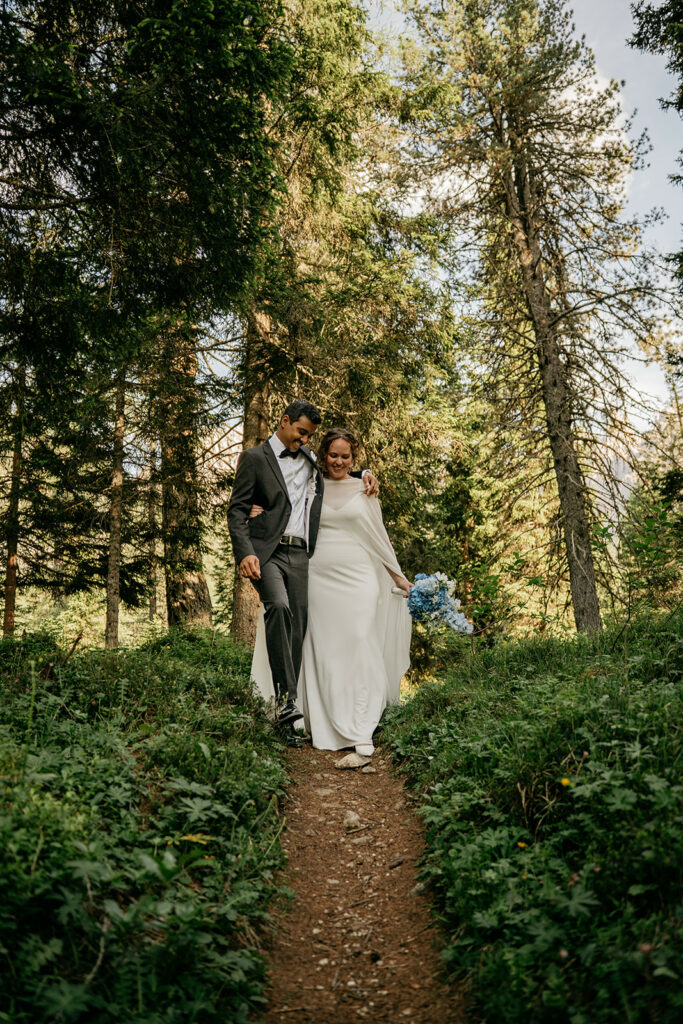Couple walking in forest wedding.