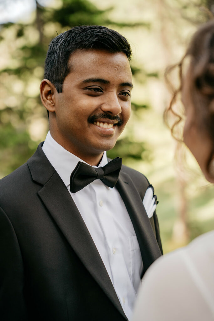 Smiling groom in black tuxedo outdoors