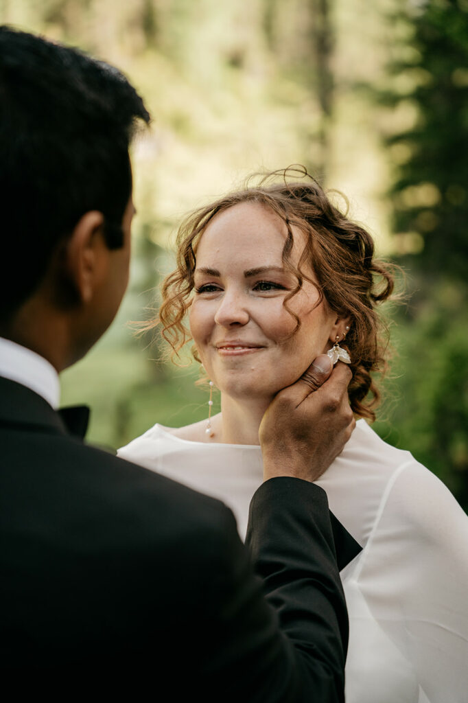 Bride and groom share intimate moment outdoors.