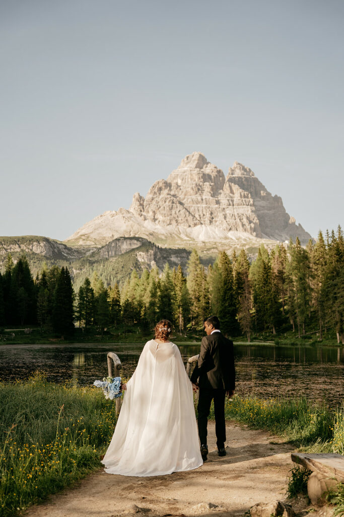Couple walking by lake, mountain in background
