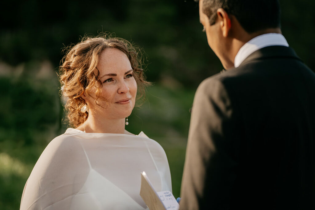 Bride and groom exchanging vows outdoors.