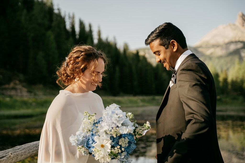Happy couple with bouquet outdoors, smiling and joyful.