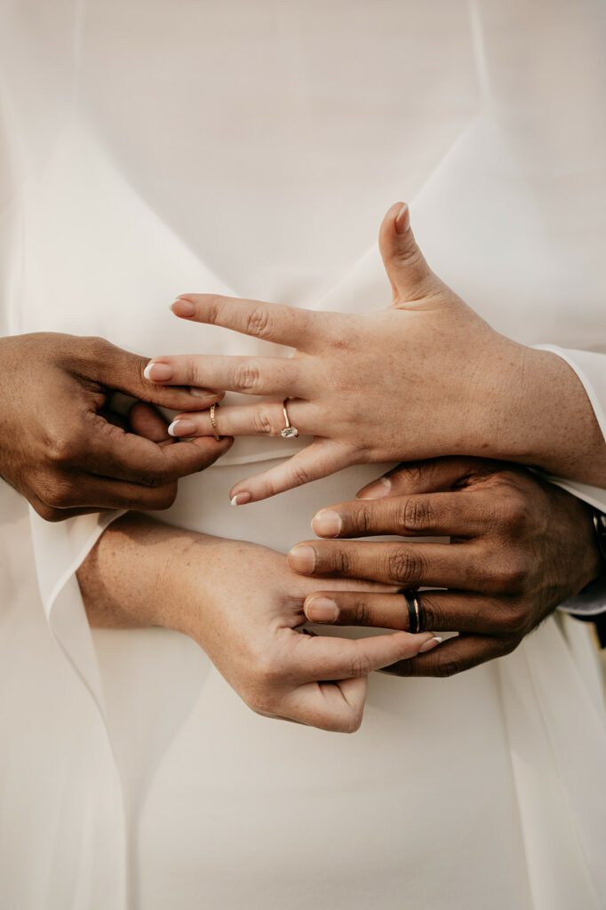 Interracial couple showing wedding rings.
