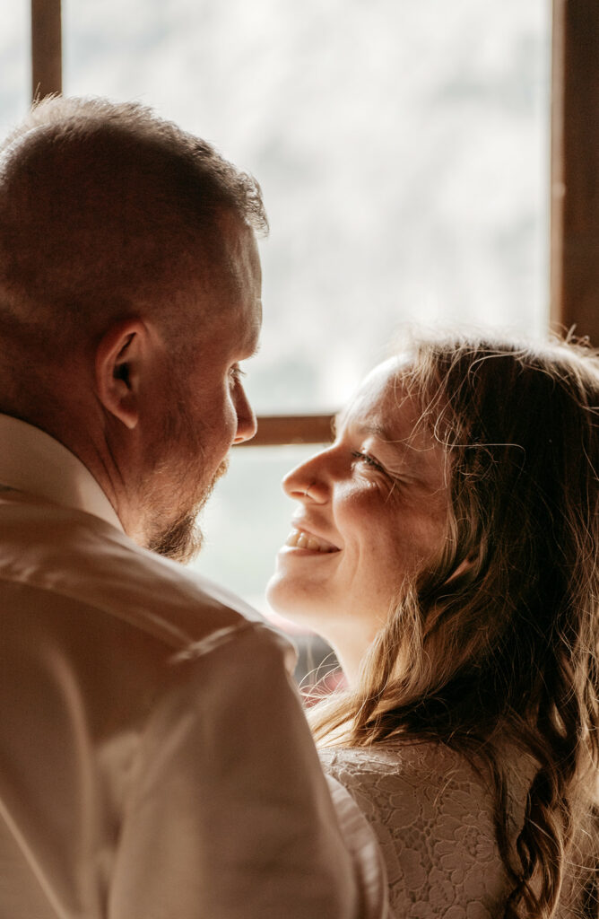 Happy couple sharing a tender moment by window.