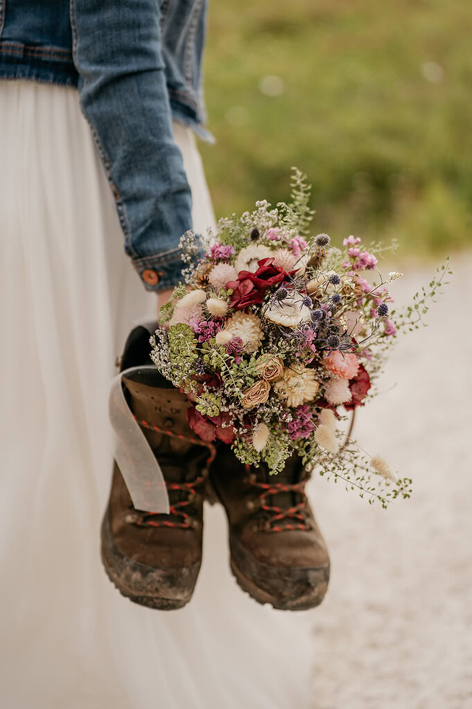 Rustic bouquet inside hiking boots, wedding theme.