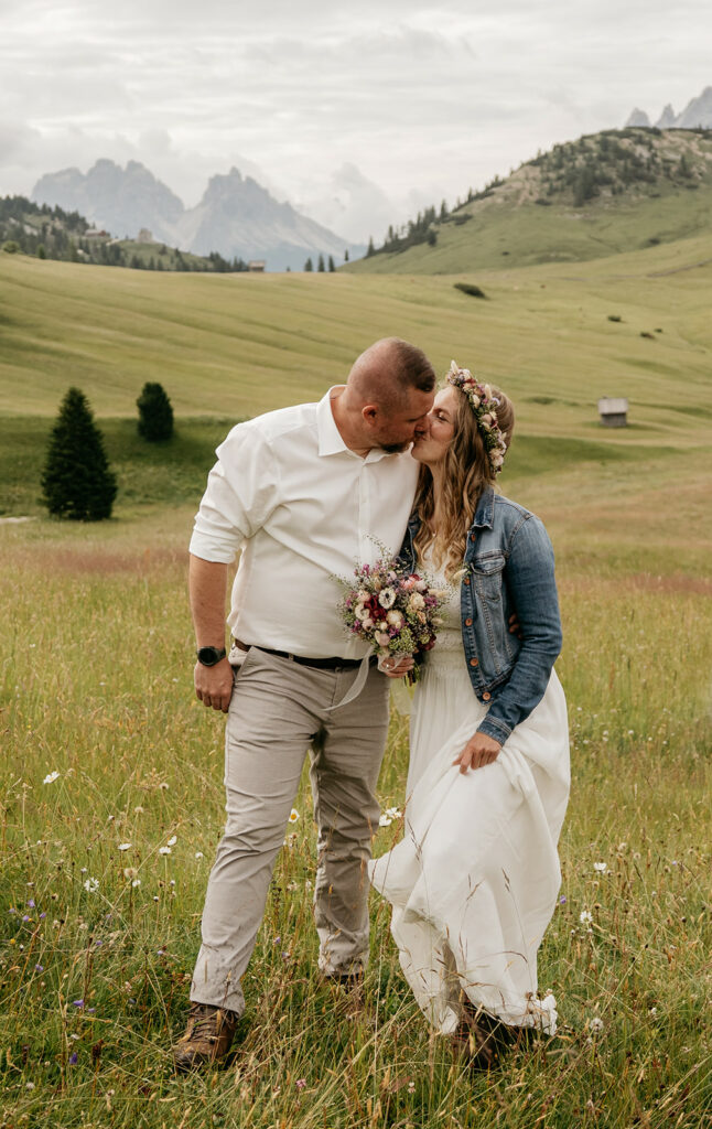 Couple kissing in mountain meadow landscape