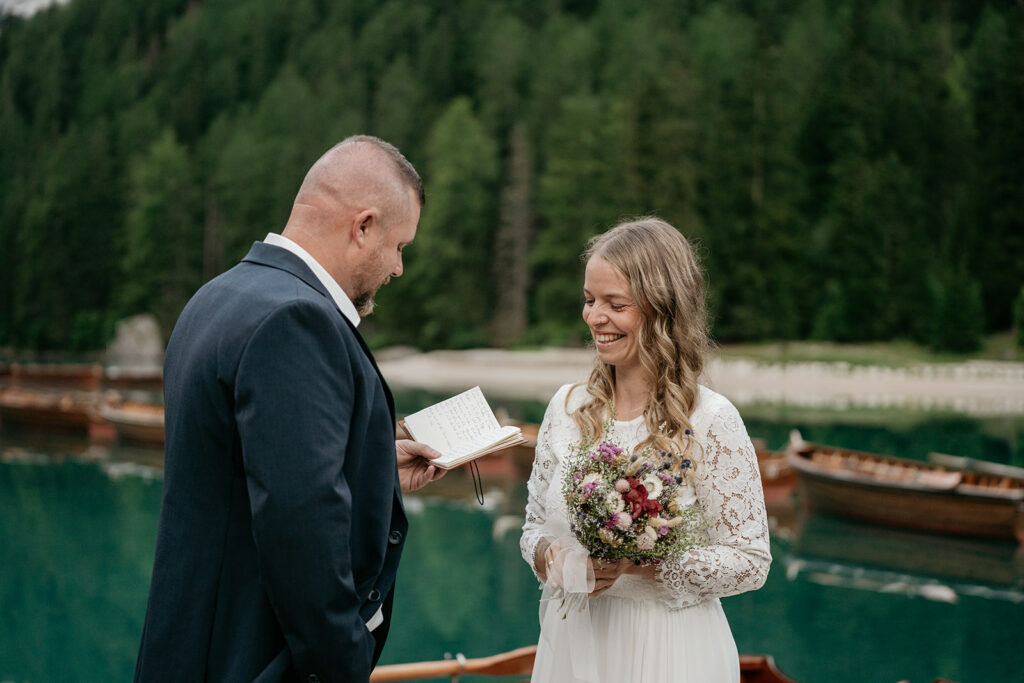 Couple exchanging vows by a scenic lake.
