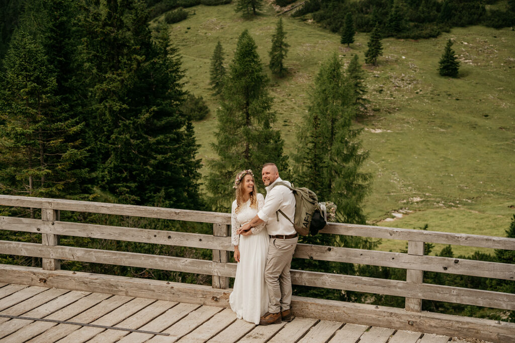 Couple hugging on a wooden bridge in forest