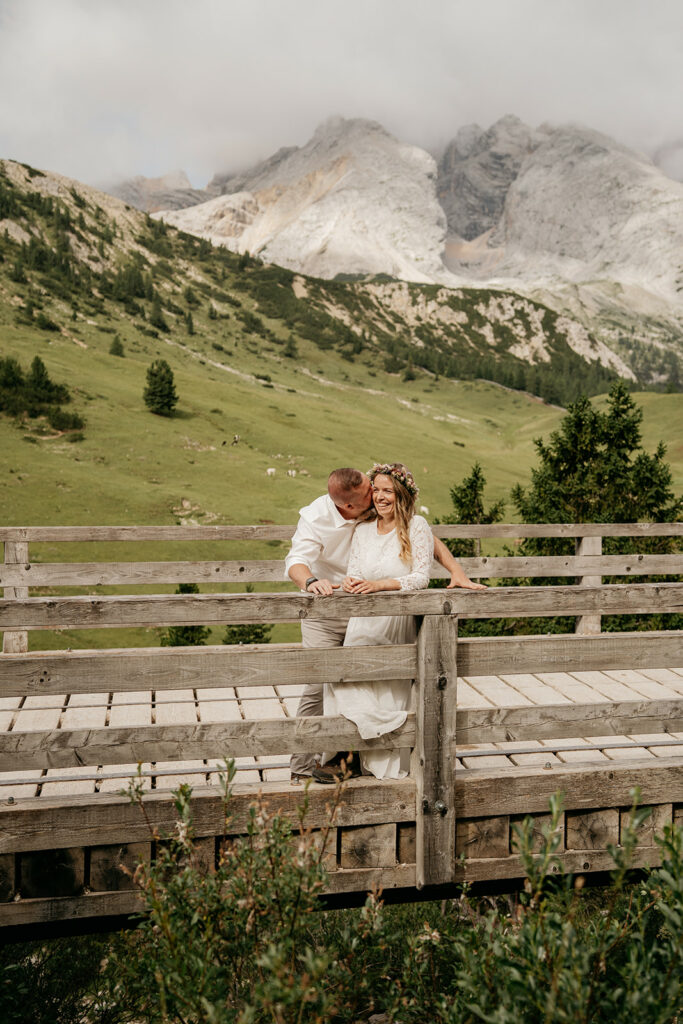 Couple on bridge with mountain background.