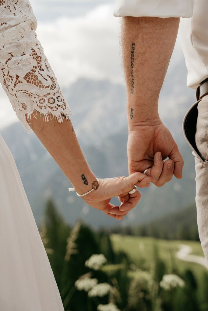 Couple holding hands with mountain background.