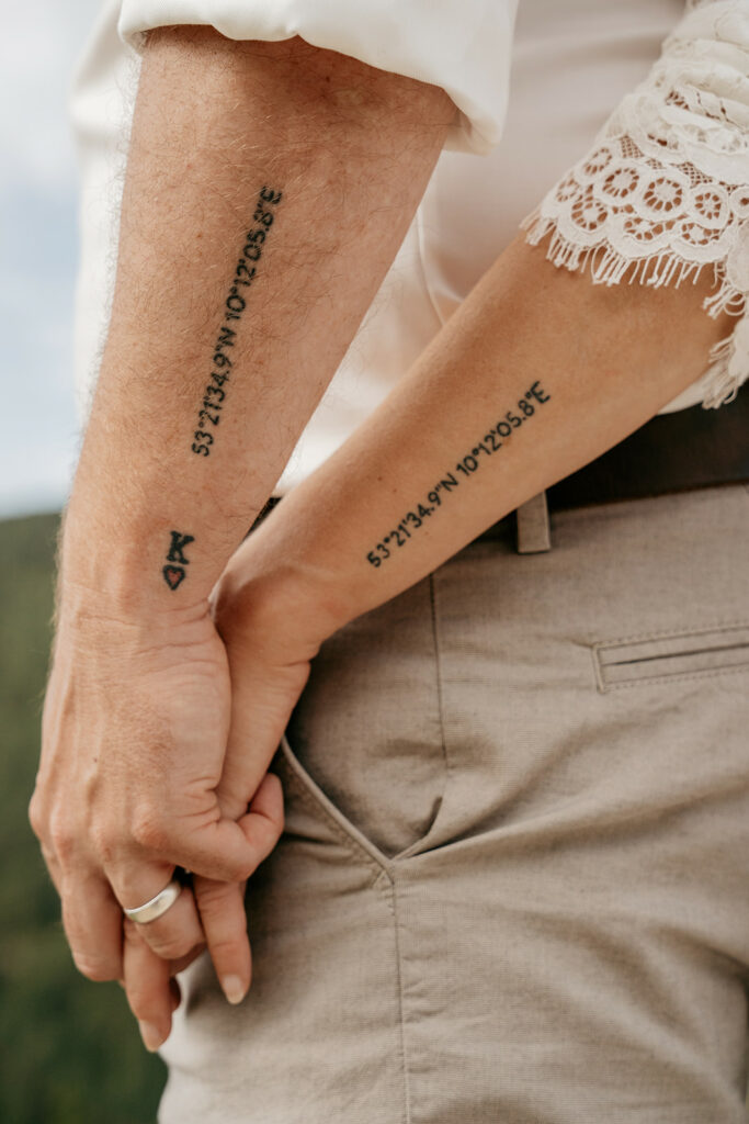 Arms with matching coordinate tattoos and lace sleeves.