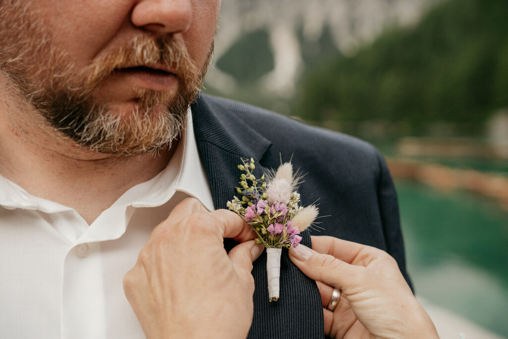 Adjusting boutonnière on suit jacket.