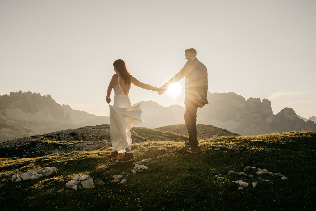 Couple holding hands on mountain at sunset